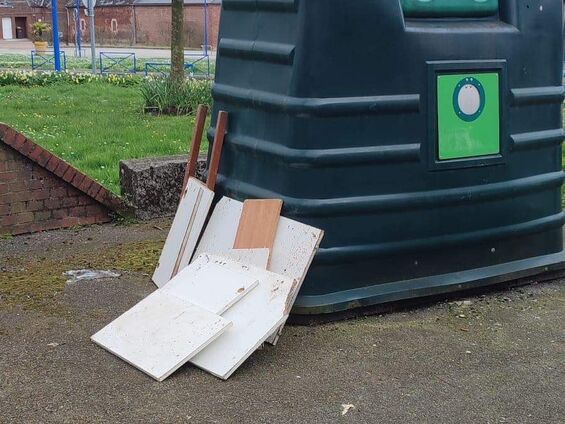 Déchets entreposés à côté du vide-ordure près du parking de la halle